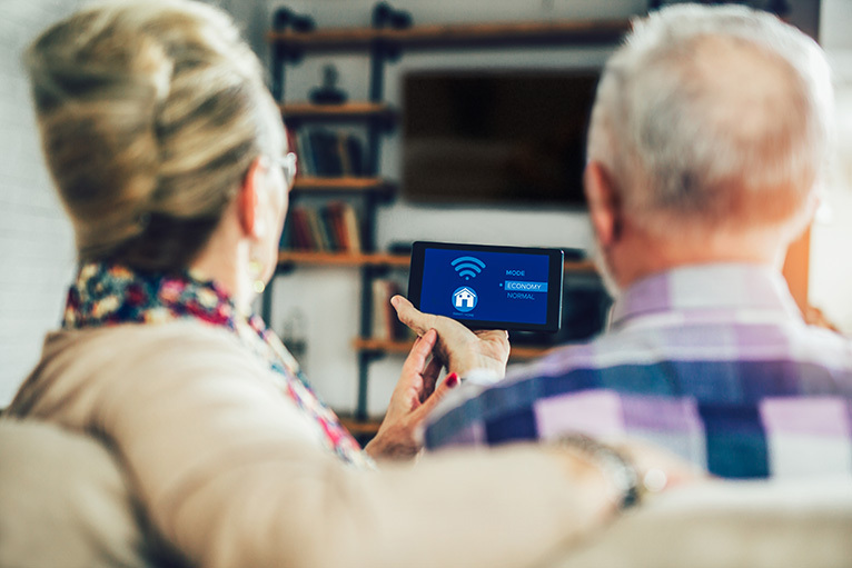 Older couple operating home tech from a phone