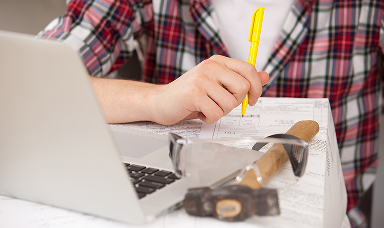 Tradesperson working with papers and a laptop