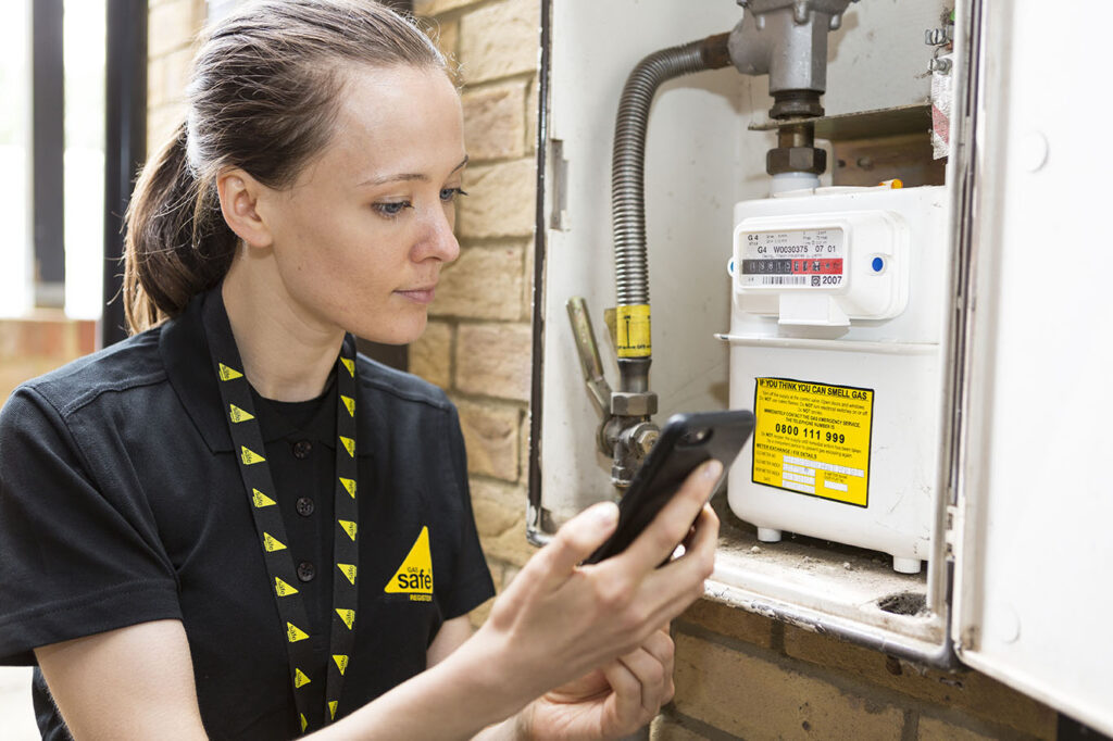 Female engineer checking a gas meter outside a home