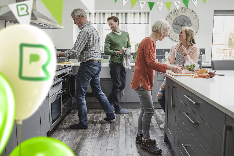 Family in refurbished kitchen with Rated People competition balloons and banners