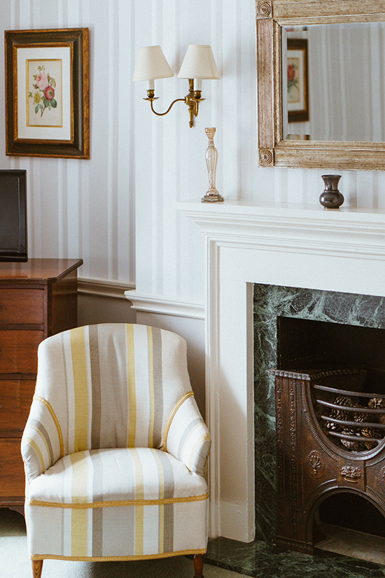 Light striped armchair in room with striped wallpaper