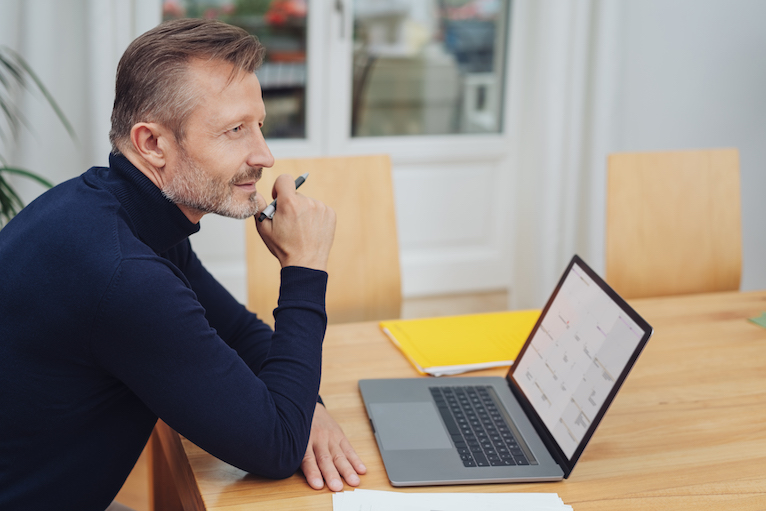 Person thinking and looking at laptop