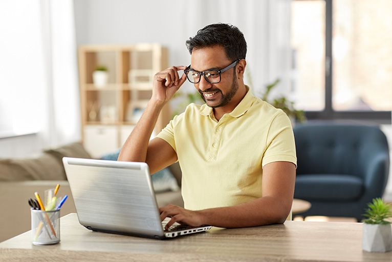 Person smiling and looking at laptop