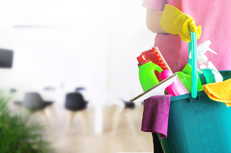 Cleaner holding cleaning supplies in bucket