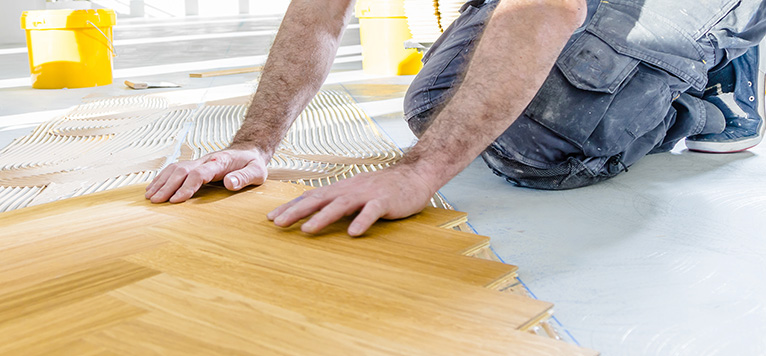 Floor fitter laying flooring