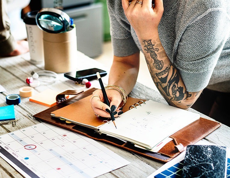 Person writing a plan in notebook