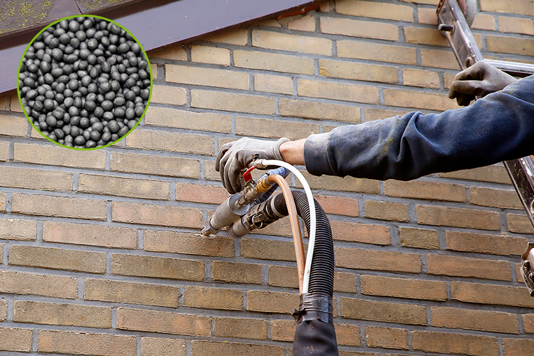 Man injecting microbead pearls in the cavity walls.