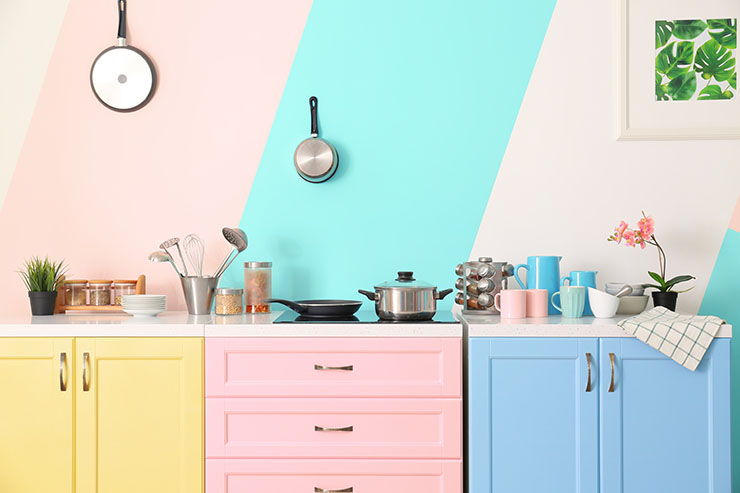 Colourful kitchen with striped wallpaper and colourful cabinets