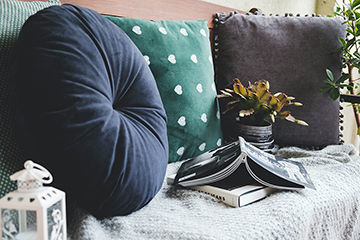 Picture of a couch with some pillows and books