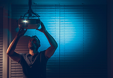 Picture of a man setting up a projector for a home extension cinema room