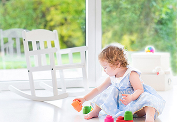 Picture of a child playing with toys by a window