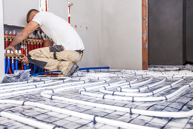 Picture of a heating engineer installing wet water underfloor heating