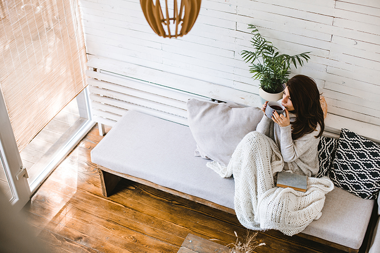 Picture of a woman sitting with book under blanket