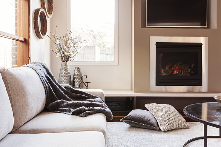 Picture of a living room with fireplace and blanket on sofa