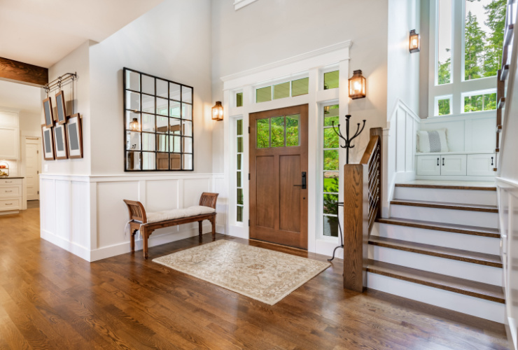 Picture of a front door and hallway with wooden staircase 